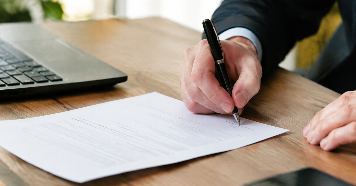 Main signant document papier avec stylo noir